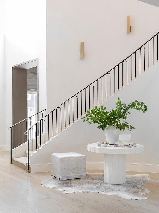 Round White Fluted Table on Curved Staircase Wall - Transitional .